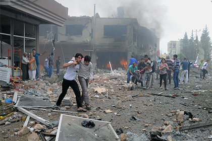 Люди помогают раненым после взрывов в городе Рейханлы