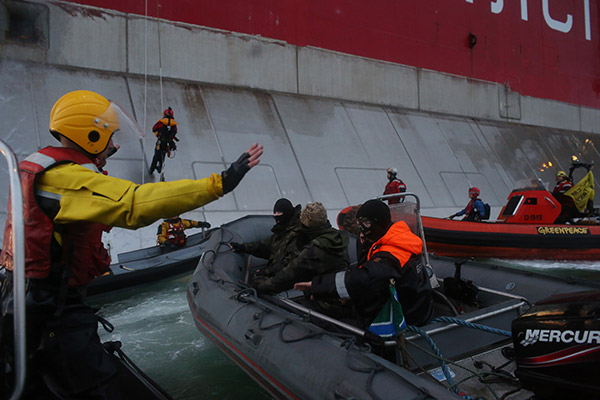 Активисты Greenpeace и российские пограничники около платформы «Приразломная»