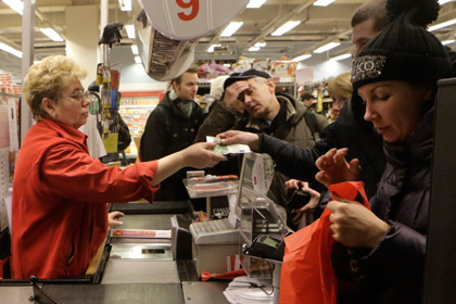 Покупатель расплачивается банкнотой евро в магазине Риги