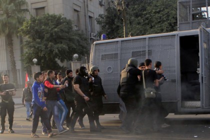 Полиция задерживает исламистов в Каире 25 января 2014 года. 