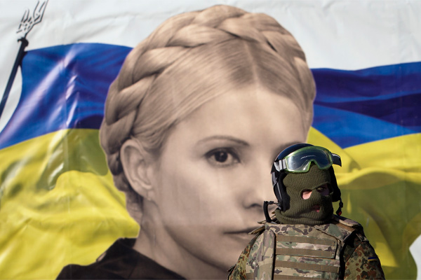 Активист «Евромайдана» на фоне портрета Юлии Тимошенко в Киеве