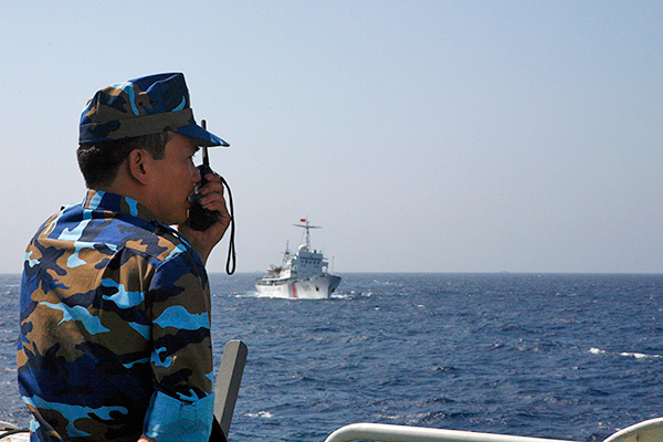 Офицер вьетнамской морской полиции контролирует китайский корабль береговой охраны в Южно-Китайском море, 16 мая 2014 года