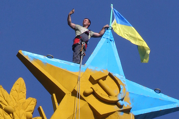 Рабочий делает селфи перед началом демонтажа украинского флага на Котельнической