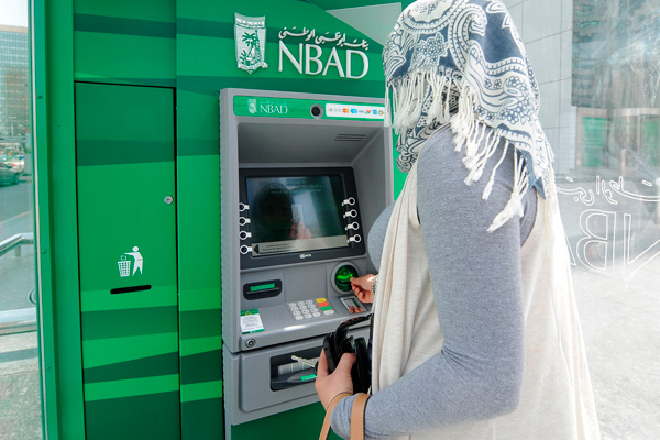 Клиентка возле банкомата Национального банка Абу-Даби, ОАЭ