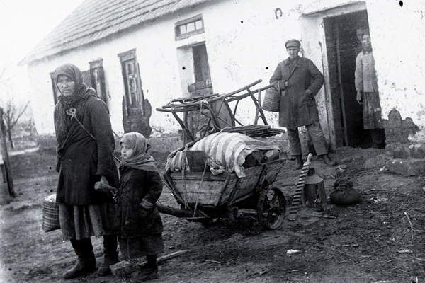 Раскулаченная семья возле своего дома, 1930 г.