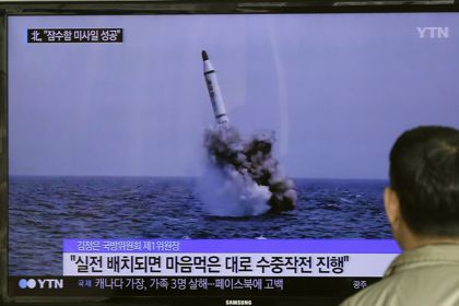 Житель Южной Кореи смотрит телерепортаж об испытаниях ракеты морского базирования в КНДР