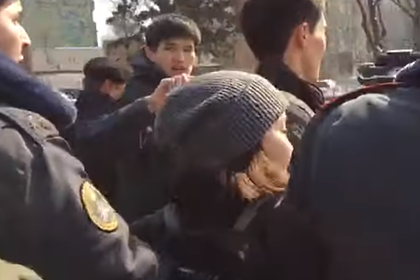 Милиционеры задерживают одну из участниц акции против насилия в Бишкеке