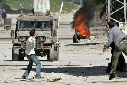 Палестинцы бросают камни в джип израильской армии
