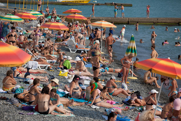 Отдыхающие загорают на пляже в городе Сочи