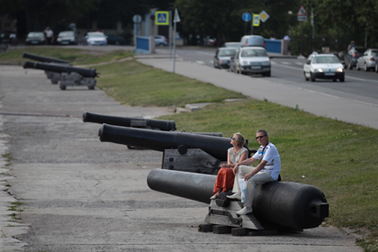 Туристы отдыхают на чугунных пушках возле Итальянского пруда в Кронштадте