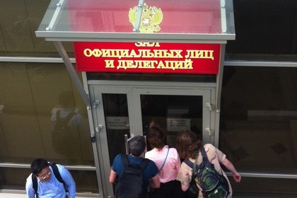 Журналисты заглядывают в двери Зала официальных лиц и делегаций в Шереметьево. 