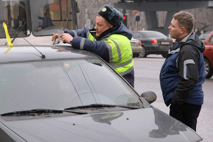 Инспектор ГИБДД проверяет документы у водителя