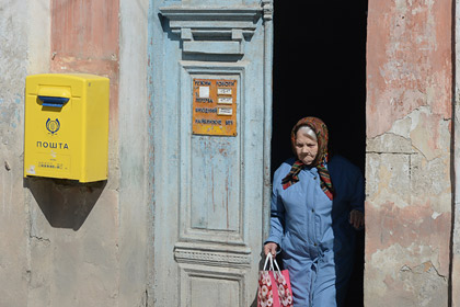Пожилая женщина у отделения почтовой связи на одной из улиц Бахчисарая.