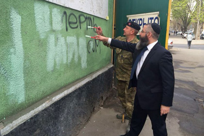 Авраам Вольф и командир УНСО Валерий Загородний закрашивают надпись на стене