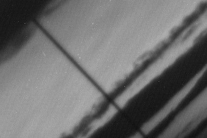 Прохождение корабля «Прогресс» через плотные слои атмосферы (белый «штрих» на светлом фоне неба левее/ниже темной наклонной линии)